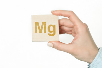 Doctor advises. Nutritionist or medical worker holds Magnesium sign, healthy lifestyle concept.