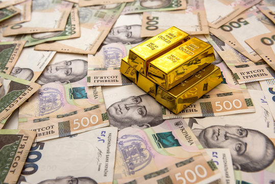 stacks of gold bars on ukraine moneu uah . top view