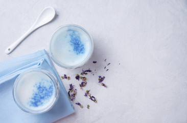 Obraz na płótnie Canvas blue matcha tea in a clear glass on a white table
