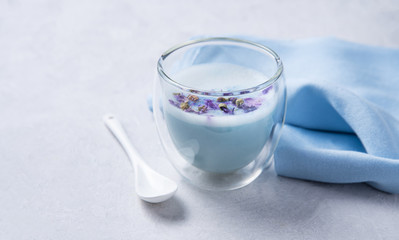 blue matcha tea in a clear glass on a white table