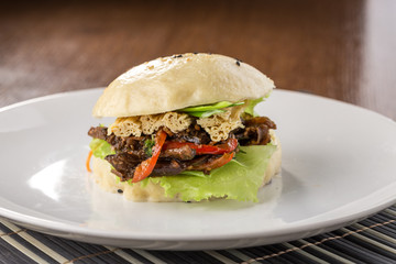 Homemade asian style gluten free burger with fried eggplant and fuzhu on wooden table