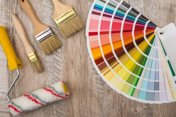 Color palette guide and paint brush roller  on wood board.