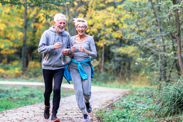 Mature couple man and woman jogging in the park