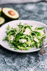 Vegetarian salad with arugula, fresh cucumber and avocado