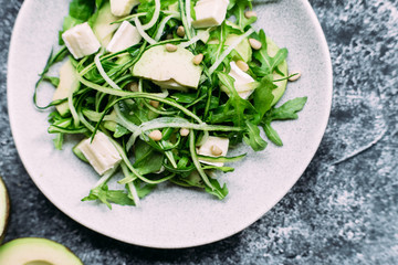 Vegetarian salad with arugula, fresh cucumber and avocado