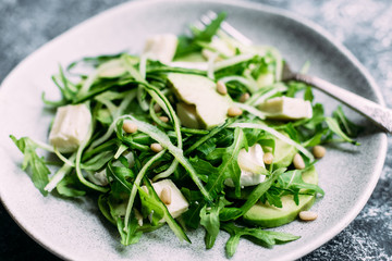 Vegetarian salad with arugula, fresh cucumber and avocado