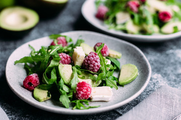Salad with arugula, avocado, raspberries and brie cheese