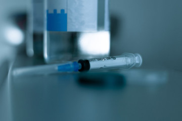 Syringe and bottle with medicines. Syringe for single use. Syringe on a blurred background