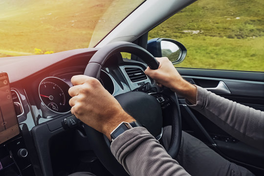 Man Driving Right Hand Car. Close-up Shot Of Man's Hands Holding Steering Wheel.