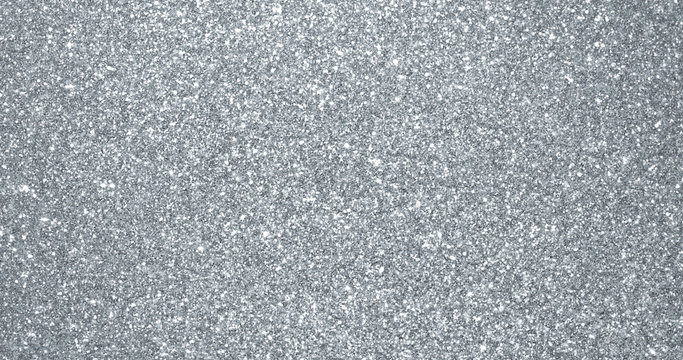 Silver glitter background, sparkling shimmer glow particles texture. Silver light sparks and glittering foil sequins background with shine sparks glare