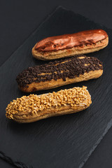eclair with custard cream and chocolate chips on black plate