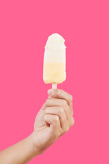 Male hand with delicious melting fruit popcicle, isolated on pink
