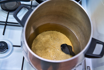 Preparing boiling olive oil with a faint flavor of natural carbon. Piece of carbon in the bottom of the pan. Caramelize produce.