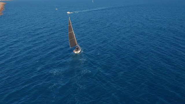 Aerial view. Sailing yacht with white sails in the open Sea.