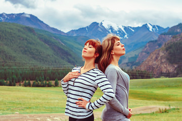 Fototapeta na wymiar two girls stand against the mountains