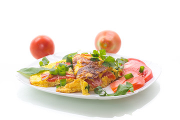 fried omelet from homemade organic eggs with tomatoes and green onions