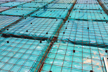 Green plastic sheeting placed beneath the reinforcing on a floating foundation.
