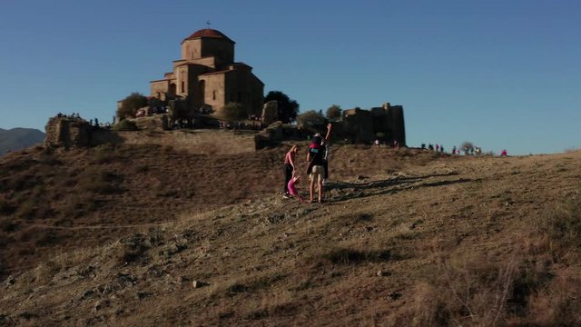 Aerial view of happy family near Jvari Monastery in Mtskheta city in summer light.