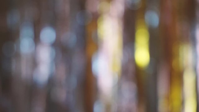 Abstract image with defocused carnival sparkles in the background. Alternating between warm and cold tones. Panning to the left.