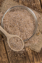 Vintage wooden table with Wheat Bran (selective focus; close-up shot)