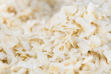 Some healthy Coconut Chips (selective focus; close-up shot)