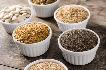 Assortment of different seeds in bowl on wooden table. Pumpkin, linen, chia, sunflower, and sesame seeds	