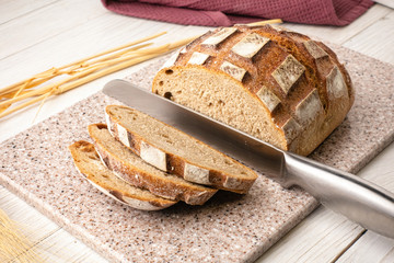 Fresh fragrant bread on a kitchen cutting board made of artificial stone