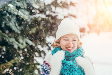 Happy attractive young blonde in winter in a snow-covered forest - a nice New Year and Christmas look