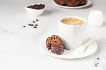 Traditional Italian homemade biscotti cookies or cantuccini with chocolate and a cup of coffee on a light grey background.