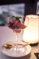 Dessert with cream and strawberries in candlelight