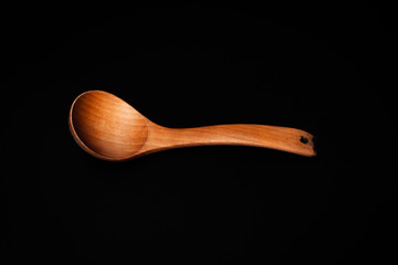 brown wooden spoon close up on black background