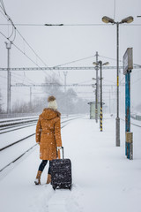 Traveler waiting for train at railway station during heavy snowfall