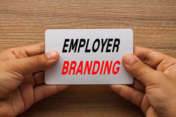 Employer Branding written on white card holding with two hands