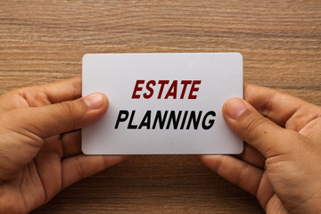Estate Planning written on white card holding with two hands