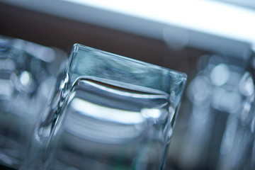 Clean washed and polished bar and pub glasses hanging over Closeup shot of empty glasses ware on...