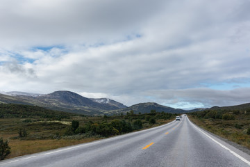 Mountains in Norway road epic scenic sky, way, clouds view. Traveling by car, driving nature tourism. Dramatic skyscape northern scandinavian sky
