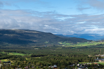 Norway nature landscape with beautifull clouds and green fields and pine forest. Great traveling view