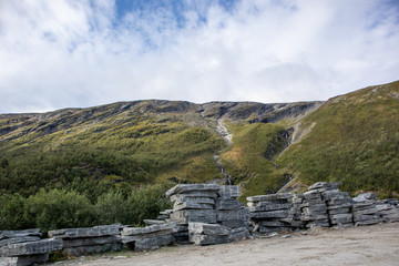 Fototapeta na wymiar Building material granite black rocks on mountain road in Norway mountains landscape