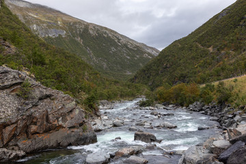 White powerful rocky river landscape with green mountains beautiful background. Nature scandinavia Norway