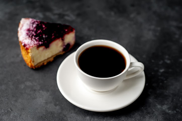 Coffee, cheesecake with currants on a white plate on a stone background, delicious breakfast with copy space for your text