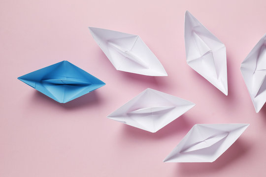 Flat lay of paper boats on background. Not like that. Individuality. Leader..