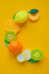 Products containing vitamin C, cut from paper on yellow background