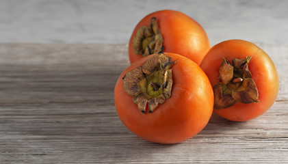 Delicious fresh persimmon fruit on a wooden table. Close-up.