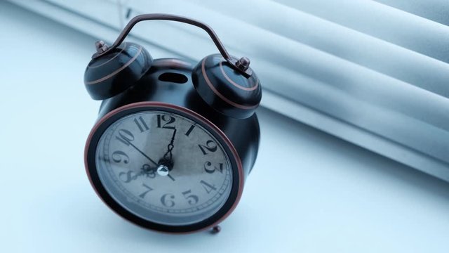 Old antique alarm clock rang early in the morning .4K video.