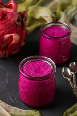 Homemade tropical smoothie made of dragon fruit on a dark background, vertical orientation