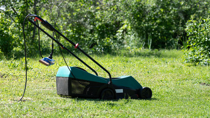 Electric Lawn Mower On The Grass.