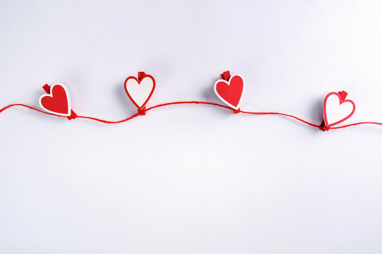 Red and white hearts hanging on rope. Valentine's Day concept. Greeting card with copy space