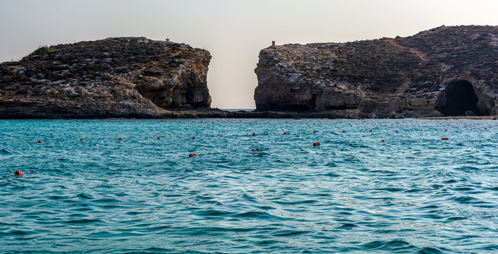 The Blue Lagoon at boat level with Cominotto island in background. It is an uninhabited Mediterranean island off the northern coast of Malta, near Comino island.