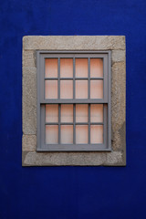 closed glass window on a blue wall with space for text and nobody