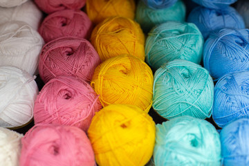 Multi-colored pink, whire, yellow, blue, white woolen threads in balls for knitting and handmade.